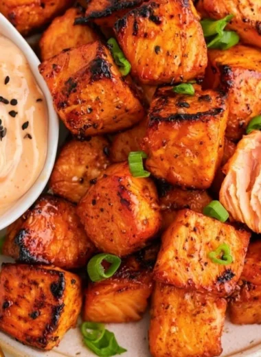 Air fryer salmon bites served with bang bang sauce on a plate