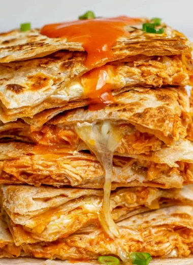 Buffalo chicken quesadillas stacked on a plate, perfect for game day snacks.