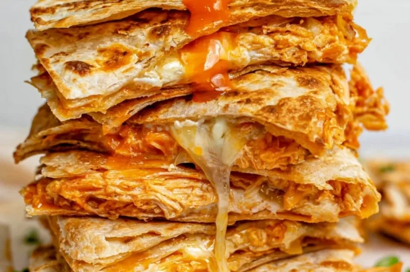 Buffalo chicken quesadillas stacked on a plate, perfect for game day snacks.