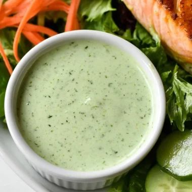 Creamy basil dressing drizzled over a fresh salad, enhancing flavor and presentation.