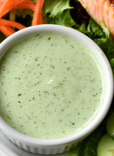 Creamy basil dressing drizzled over a fresh salad, enhancing flavor and presentation.