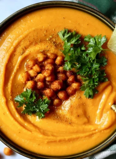Bowl of Moroccan sweet potato and chickpea soup garnished with herbs