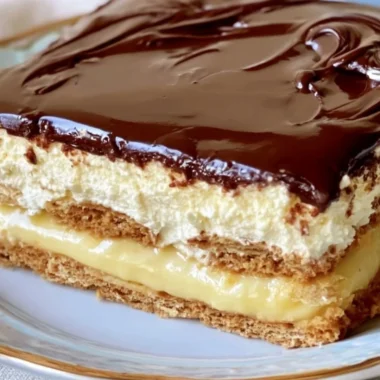 Delicious no-bake eclair cake topped with chocolate frosting and whipped cream