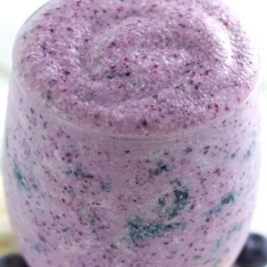 Healthy blueberry banana protein smoothie in a glass with fresh fruit
