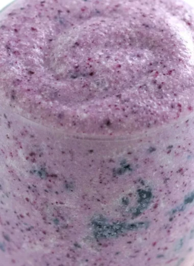 Healthy blueberry banana protein smoothie in a glass with fresh fruit