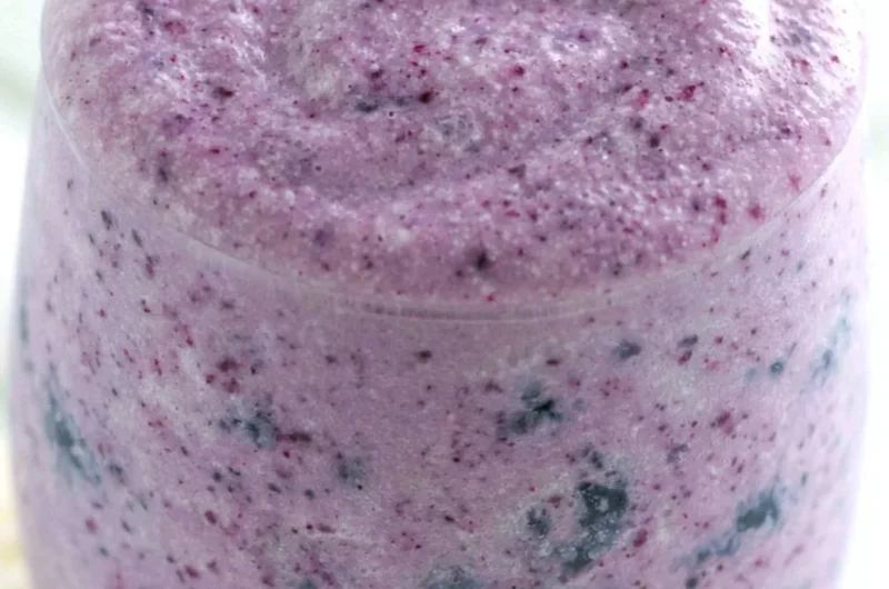 Healthy blueberry banana protein smoothie in a glass with fresh fruit