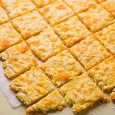 Plate of homemade sourdough crackers topped with cheddar cheese