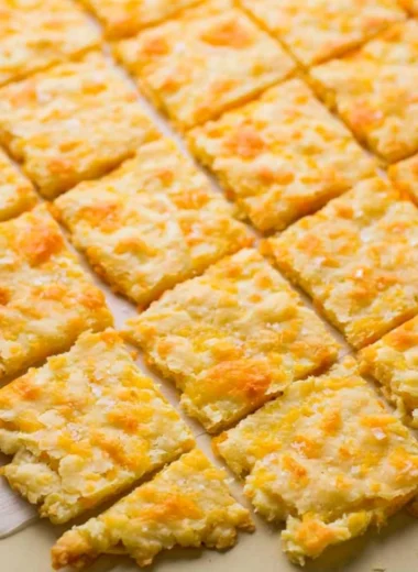 Plate of homemade sourdough crackers topped with cheddar cheese
