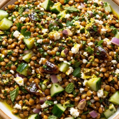 A vibrant Lentil Salad with Feta cheese, herbs, and vegetables in a bowl.