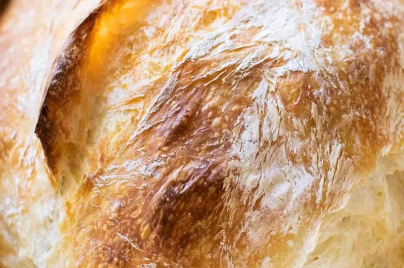 Loaf of freshly baked no-fail sourdough bread on a wooden table
