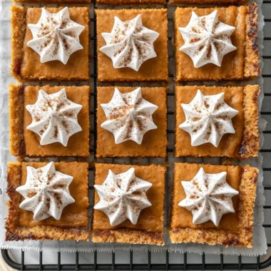 Delicious Pumpkin Pie Bars topped with whipped cream and spices