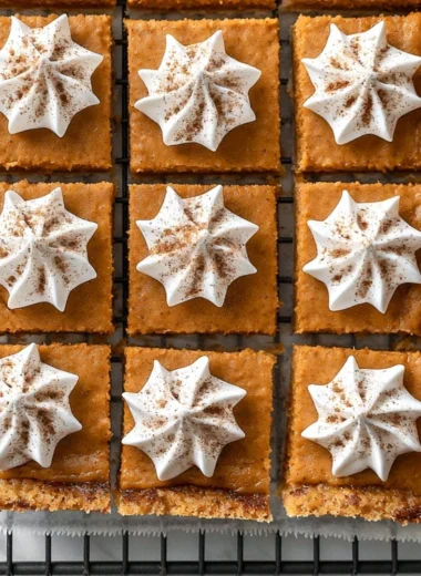 Delicious Pumpkin Pie Bars topped with whipped cream and spices