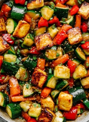 Delicious vegan zucchini stir fry with tofu and colorful vegetables in a bowl.