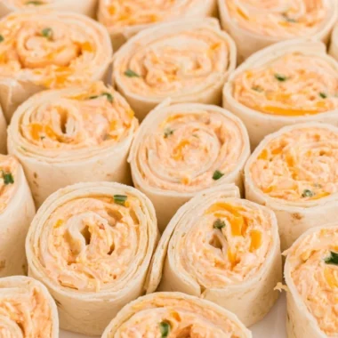 Buffalo Chicken Pinwheels served on a plate, garnished with fresh herbs.