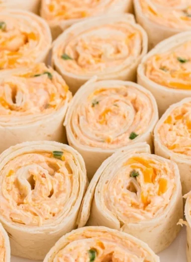 Buffalo Chicken Pinwheels served on a plate, garnished with fresh herbs.