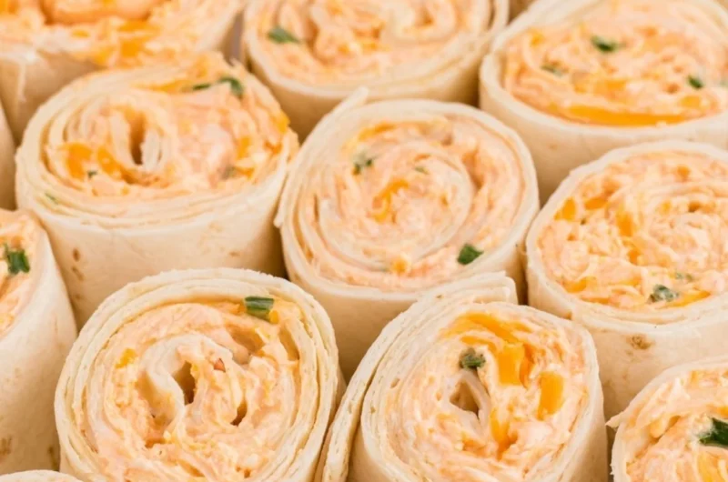 Buffalo Chicken Pinwheels served on a plate, garnished with fresh herbs.